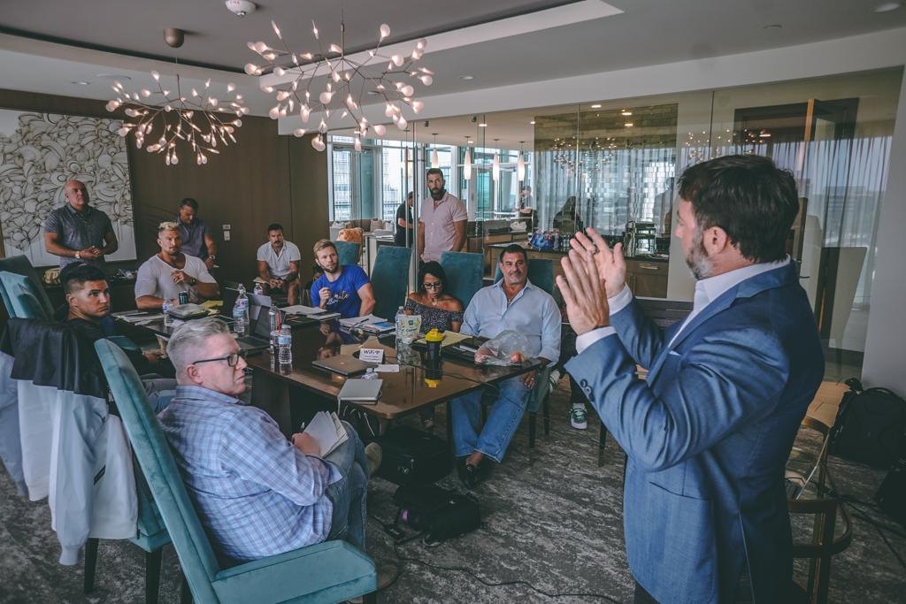 Michael Kimelman speaking to a room of men around a table